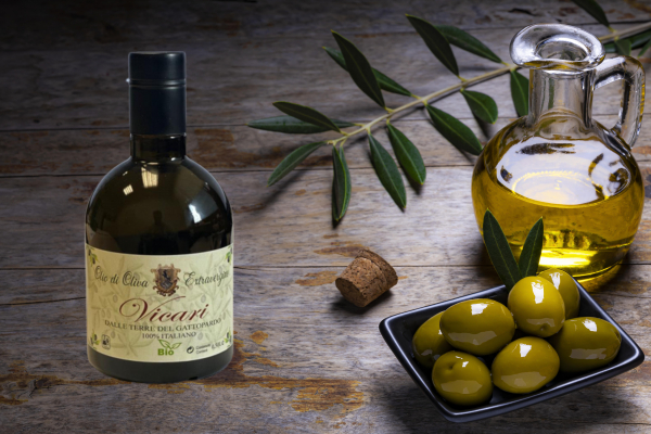 tasty_looking_olives_extra_virgin_olive_oil_olive_leafs_dark_wooden_background.jpg